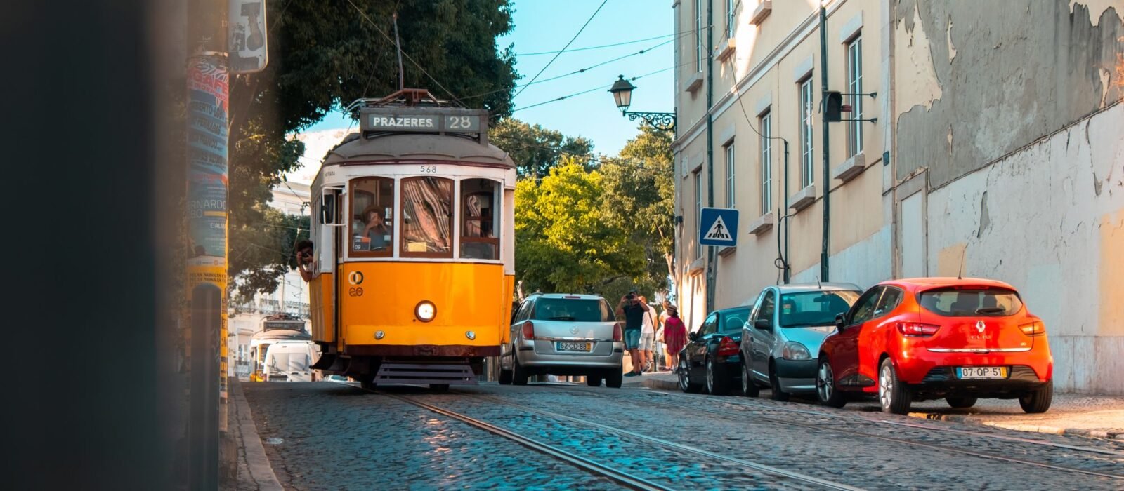 A yellow tram on a cobbled street in Lisbon